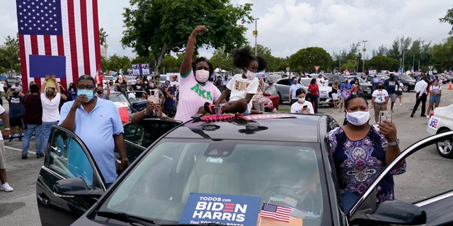 People cheer at a car rally as former President Barack Obama speaks while campaigning for Democratic presidential candidate former Vice President Joe Biden at Florida International University, Saterdag, Okt.. 24, 2020, in North Miami, Fla. (AP Photo/Lynne Sladky)