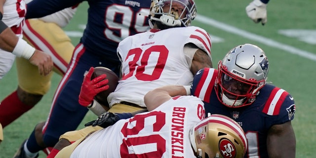 San Francisco 49ers running back Jeff Wilson Jr. (30) spins to gains yardage behind the block of tackle Daniel Brunskill (60) in the first half of an NFL football game against the New England Patriots, 일요일, 10 월. 25, 2020, 폭스 버러, 질량. (AP Photo/Steven Senne)