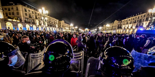 Police face people protesting the government restriction measures to curb the spread of COVID-19 in Turin, Italy, Monday, Oct. 26, 2020. (Claudio Furlan/LaPresse via AP)