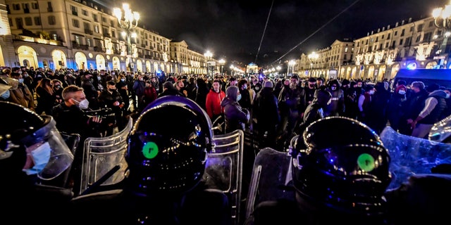 Police face people protesting the government restriction measures to curb the spread of COVID-19 in Turin, Italy, Monday, Oct. 26, 2020. (Claudio Furlan/LaPresse via AP)