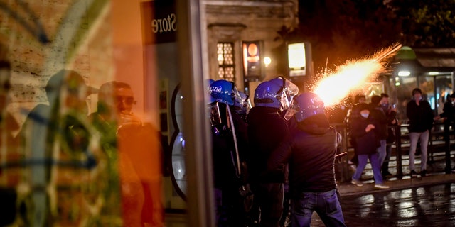 Police fire tear gas as clashes broke out during a protest against the government restriction measures to curb the spread of COVID-19 in Turin, Italy, Monday, Oct. 26, 2020. (Claudio Furlan/LaPresse via AP)