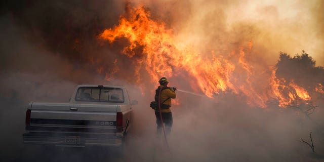 A firefighter battles the Silverado Fire Monday, Oct. 26, 2020, in Irvine, Calif. (AP Photo/Jae C. Hong)