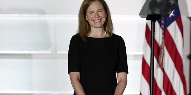 Justice Amy Coney Barrett listens as President Donald Trump speaks before Supreme Court Justice Clarence Thomas administers the Constitutional Oath to Barrett on the South Lawn of the White House White House in Washington, Monday, Oct. 26, 2020, after Barrett was confirmed to be a Supreme Court justice by the Senate earlier in the evening. Barrett's confirmation process was much faster than those of her recent predecessors. (AP Photo/Alex Brandon)