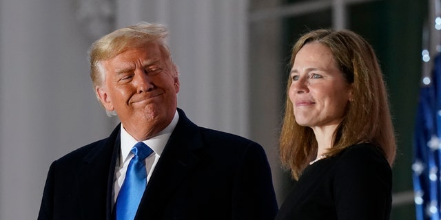 President Donald Trump and Amy Coney Barrett stand on the Blue Room Balcony after Supreme Court Justice Clarence Thomas administered the Constitutional Oath to her on the South Lawn of the White House in Washington, Monday, Oct. 26, 2020. Barrett and the two other Supreme Court justices Trump appointed during his four-year term are widely considered to be among his biggest accomplishments.  (AP Photo/Patrick Semansky)