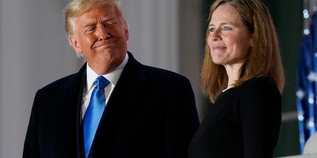 President Donald Trump and Amy Coney Barrett stand on the Blue Room Balcony after Supreme Court Justice Clarence Thomas administered the Constitutional Oath to her on the South Lawn of the White House in Washington, Monday, Oct. 26, 2020. Barrett and the two other Supreme Court justices Trump appointed during his four-year term are widely considered to be among his biggest accomplishments.  (AP Photo/Patrick Semansky)