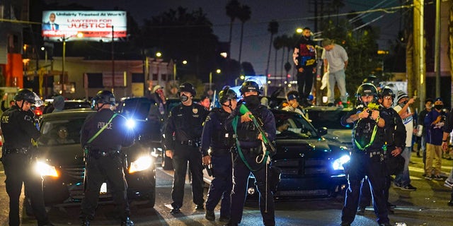 Members of the Los Angeles Police order fans to disperse on Sunset Boulevard after watching the broadcast of Game 6 of the baseball World Series in Los Angeles on Tuesday, Oct. 27, 2020. The Los Angeles Dodgers defeated the Tampa Bay Rays 3-1 and won the World Series. (AP Photo/Damian Dovarganes)