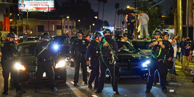 Members of the Los Angeles Police order fans to disperse on Sunset Boulevard after watching the broadcast of Game 6 of the baseball World Series in Los Angeles on Tuesday, Oct. 27, 2020. The Los Angeles Dodgers defeated the Tampa Bay Rays 3-1 and won the World Series. (AP Photo/Damian Dovarganes)