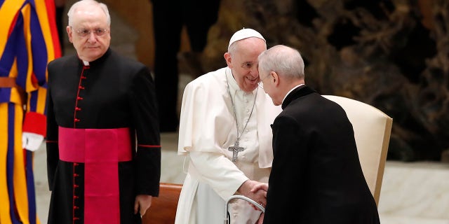Pope Francis shakes hands with Monsignor Luis Maria Rodrigo Ewart as he arrives in the Paul VI Hall at the Vatican for his weekly general audience, 수요일, 10 월. 28, 2020. (AP Photo/Alessandra Tarantino)