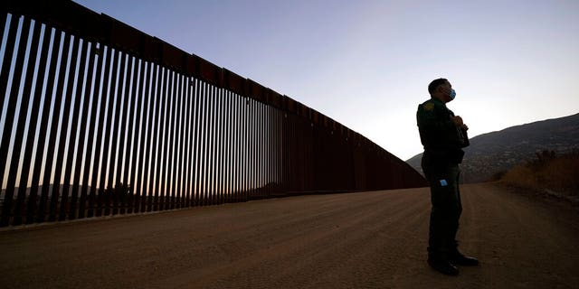 Border Patrol agent Justin Castrejon speaks in front of newly replaced border wall sections Thursday, Sept. 24, 2020, near Tecate, Calif. Top Trump administration officials will visit South Texas five days before Election Day to announce they have completed 400 miles of U.S.-Mexico border wall, attempting to show progress on perhaps the president's best-known campaign promise four years ago. But most of the wall went up in areas that already had smaller barriers. (AP Photo/Gregory Bull)