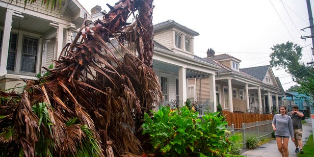 People walk along a sidewalk in New Orleans as the outer eye wall of Hurricane Zeta passed by the city, Oct. 28. (Chris Granger/The Times-Picayune/The New Orleans Advocate via AP)