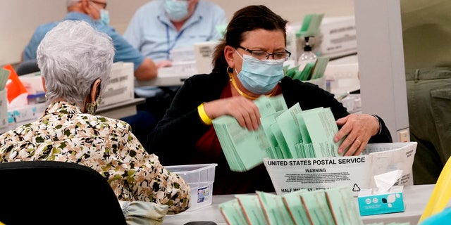 Election workers sort ballots Wednesday, Ott. 21, 2020, at the Maricopa County Recorder's Office in Phoenix. (AP Photo/Matt York)
