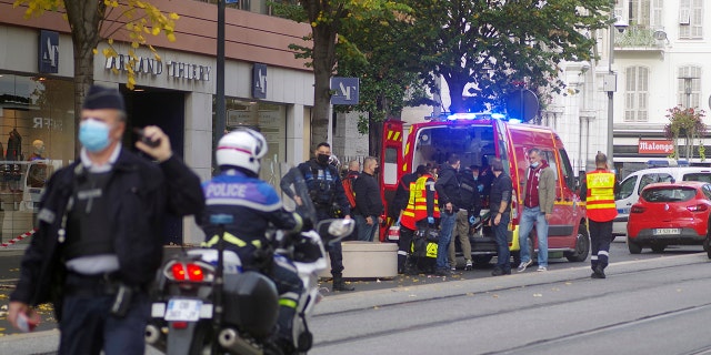 French policemen and firemen stand next to Notre Dame church after a knife attack, in Nice, France, Thursday, Oct. 29, 2020. French anti-terrorism prosecutors are investigating a knife attack at a church in the Mediterranean city of Nice that killed two people and injured several others. (AP Photo/Alexis Gilli)