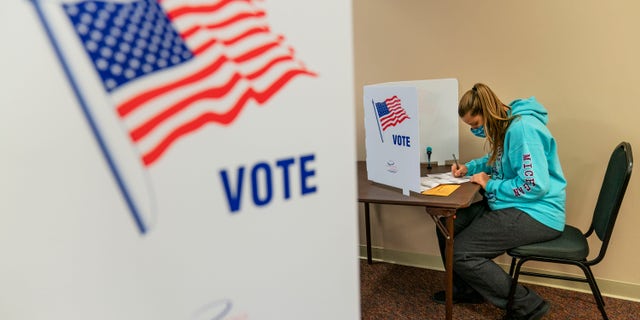 Brooke Hader, 18, votes for the first time since becoming old enough to be eligible, as she fills out her ballot during absentee early voting for the general election in Sterling Heights, Ek., Donderdag, Okt.. 29, 2020. (AP Photo/David Goldman)