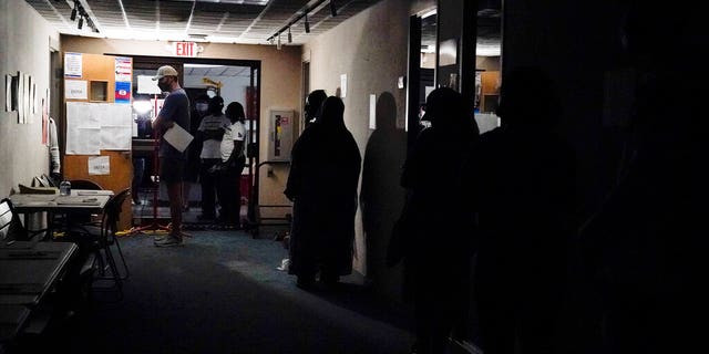 A line of voters forms during early voting at the Dunwoody Library after Hurricane Zeta knocked out power in the surrounding areas on Oct. 29, 2020, in Dunwoody, 嘎. (美联社照片/布林·安德森)