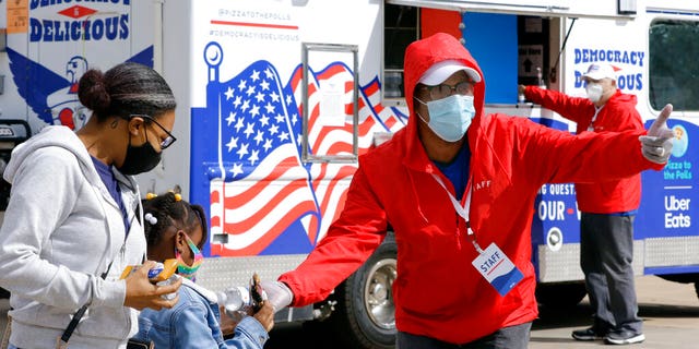 A staff member distributes a truck for water and snacks in front of the Democrats in Houston on Thursday, October 29, 2020. The truck is provided by pizza to polls and Uber restaurants.