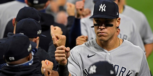 New York Yankees' Aaron Judge (99) gets a fist bump after the Yankees defeated the Cleveland Indians 12-3 in Game 1 of an American League wild-card baseball series, Tuesday, Sept. 29, 2020, in Cleveland. (AP Photo/David Dermer)