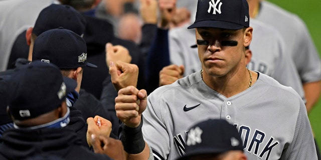 New York Yankees' Aaron Judge (99) gets a fist bump after the Yankees defeated the Cleveland Indians 12-3 in Game 1 of an American League wild-card baseball series, Tuesday, Sept. 29, 2020, in Cleveland. (AP Photo/David Dermer)