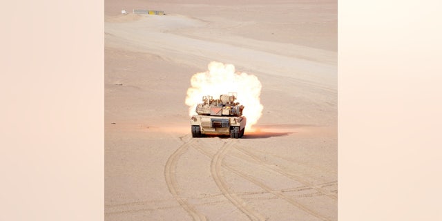 An M1A2 Abrams tanks assigned to 1st Battalion, 66th Armor Regiment, 3rd Armored Brigade Combat Team, 4th Infantry Division, fires a 120mm Sabot tank round at a target during Gunnery Live Fire Qualifications at the Udairi Range Complex, Kuwait, April 26, 2015 - file photo.