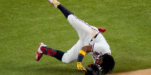 Atlanta Braves' Ronald Acuna Jr. falls at first base during the sixth inning in Game 4 of a baseball National League Championship Series against the Los Angeles Dodgers Thursday, Oct. 15, 2020, in Arlington, Texas. (AP Photo/Sue Ogrocki)