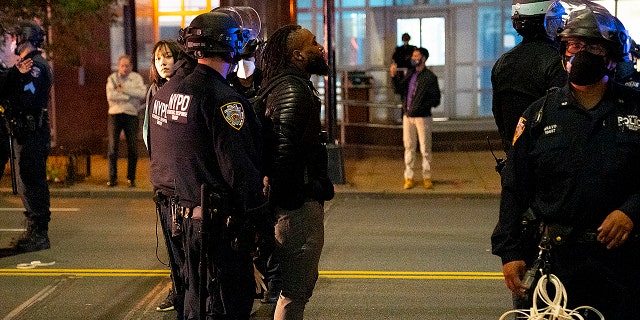 New York Police Department officers wearing masks arrest a man, center, following a protest of 200 people October 27, 2020 in the Brooklyn borough of New York City. Protesters clashed with police in response to the shooting death of Walter Wallace, an armed Black man, in Philadelphia, PA. (Photo by Robert Nickelsberg/Getty Images)