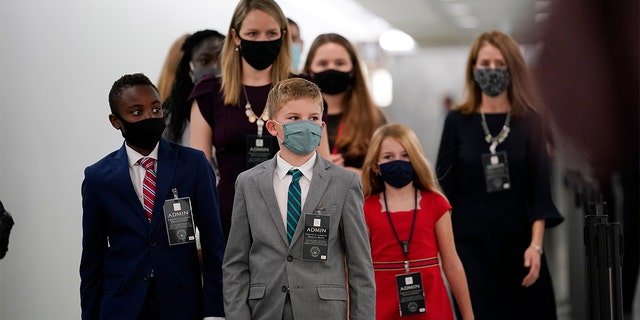 The children of Supreme Court nominee Amy Coney Barrett arrive on Capitol Hill before she will begin her confirmation hearing before the Senate Judiciary Committee, Monday, Oct. 12, 2020 on Capitol Hill in Washington. (AP Photo/J. Scott Applewhite)