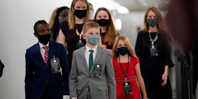 The children of Supreme Court nominee Amy Coney Barrett arrive on Capitol Hill before she will begin her confirmation hearing before the Senate Judiciary Committee, Monday, Oct. 12, 2020 on Capitol Hill in Washington. (AP Photo/J. Scott Applewhite)