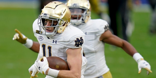 Notre Dame wide receiver Ben Skowronek, left, heads to the end zone as teammate Avery Davis (3) cheers him on after making a catch against Pittsburgh during the first half of an NCAA college football game, Saturday, Oct. 24, 2020, in Pittsburgh. (AP Photo/Keith Srakocic)