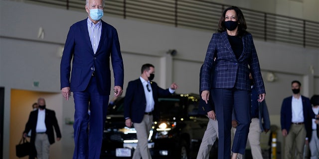 Democratic presidential candidate former Vice President Joe Biden and vice presidential candidate Sen. Kamala Harris, D-Calif., walk together to speak to the media at Phoenix Sky Harbor International Airport, in Phoenix, Thursday, Oct. 8, 2020. (AP Photo/Carolyn Kaster)