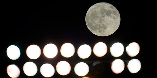 A rare Halloween blue moon moon rises over a bank of lights at Falcon Stadium in the second half of an NCAA college football game between Air Force and Boise State, 토요일, 10 월. 31, 2020, at Air Force Academy, Colo.