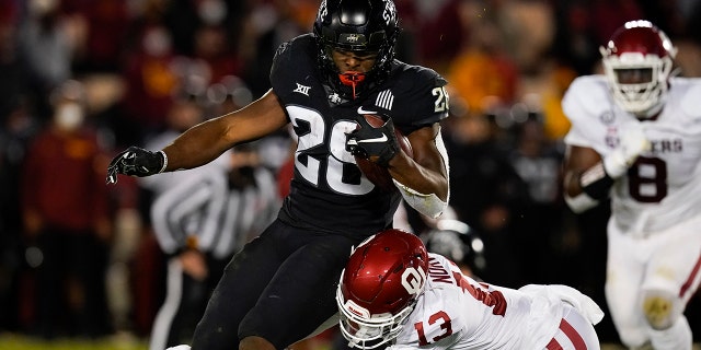 Iowa State running back Breece Hall (28) breaks a tackle by Oklahoma defensive back Tre Norwood (13) during the first half an NCAA college football game, Saturday, Oct. 3, 2020, in Ames, Iowa. (AP Photo/Charlie Neibergall)
