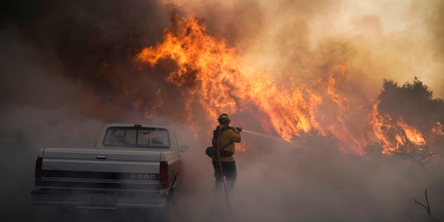 Firefighter Raymond Vasquez battles the Silverado Fire Monday, Oct. 26, 2020, in Irvine, Calif.