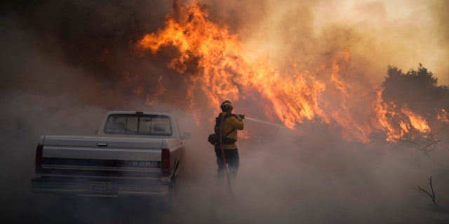 Firefighter Raymond Vasquez battles the Silverado Fire Monday, Oct. 26, 2020, in Irvine, Calif.