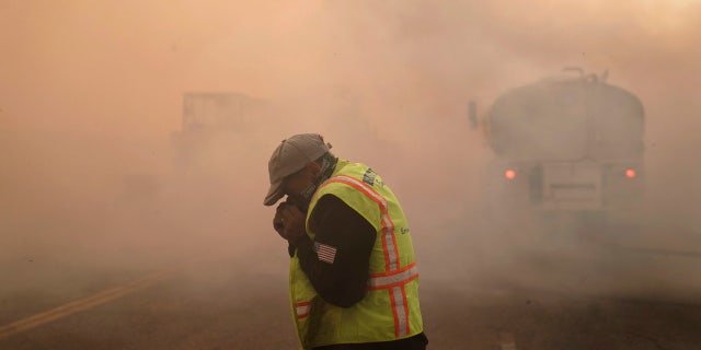 Len Brongo struggles with smoke from the Silverado Fire Monday, Oct. 26, 2020, in Irvine, Calif.