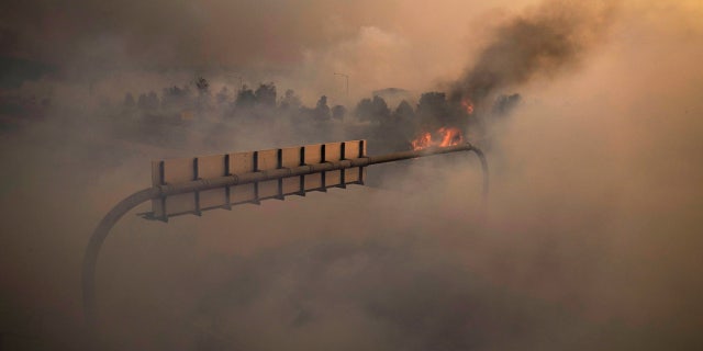 Smoke from the Silverado Fire fills the air along the 241 State Highway Monday, Oct. 26, 2020, in Irvine, Calif.