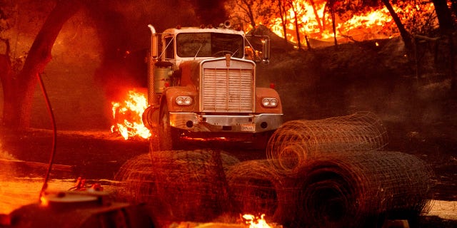 Flames from the Glass Fire burn a truck in a Calistoga, Calif., vineyard Thursday, Oct. 1, 2020.