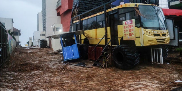 Tree debris fills a street where a kiosk stands crooked in the aftermath of Hurricane Delta in Cancun, Mexico, Wednesday, Oct. 7, 2020.