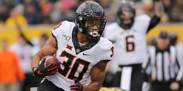 FILE - In this Saturday, Nov. 23, 2019 file photo, Oklahoma State's Chuba Hubbard (30) carries the ball during the second quarter of an NCAA college football game against West Virginia in Morgantown, W.Va. (AP Photo/Chris Jackson, File)