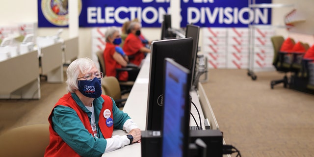 Election judge Mary Ann Thompson, front, checks the ballots at the Refereeing Section of the Denver Elections Division in Denver, Colo. On Thursday.  October 29, 2020 (Photo by Hyoung Chang / MediaNews Group / The Denver Post via Getty Images)