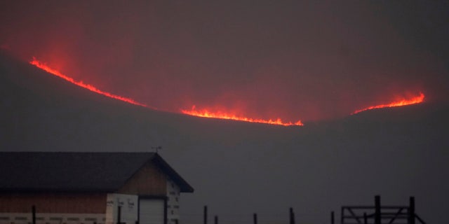 Flames rise from mountain ridges as a wildfire burns, Thursday, Oct. 22, 2020, near Granby, Colo.
