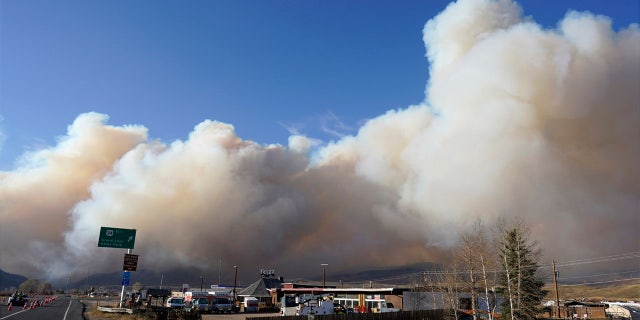 Smoke rises from mountain ridges as the East Troublesome Fire burns near Granby, Colo.