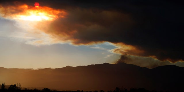 The smoke plume obscures the sun as smoke tops a ridge in this view from 75th Street as several wildfires burn in the state Wednesday, Oct. 21, 2020, in Niwot, Colo.
