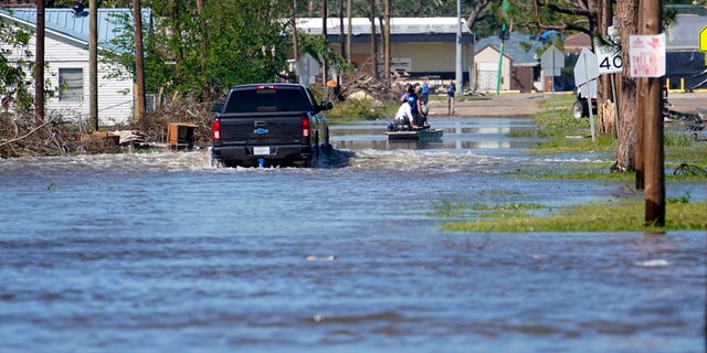 A truck drives through floodwaters in a neighborhood in Lake Charles, La., Saturday, Oct. 10, 2020, after Hurricane Delta moved through on Friday.