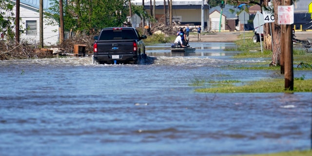 A truck drives through floodwaters in a neighborhood in Lake Charles, La., Saturday, Oct. 10, 2020, after Hurricane Delta moved through on Friday.