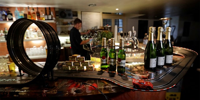 A bartender prepares a drink after turning a bar area into an electric car track. (REUTERS/David W Cerny)