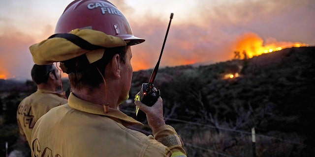 Firefighters keep a lookout for spot fires on a hillside during the Silverado Fire in Lake Forest, California, U.S., on Monday, Oct. 26, 2020.