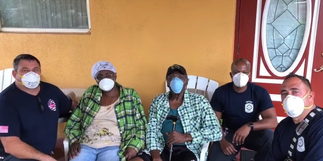 Prince Pinkney and his wife Rebecca sit with first responders from Fort Lauderdale Fire Rescue who came to his aid after he was suffering from heat exhaustion.