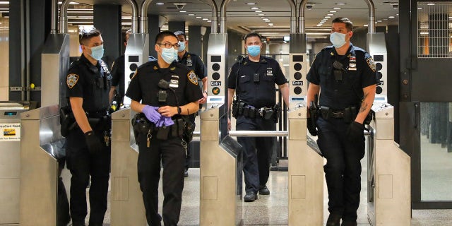 FILE PHOTO: Police officers on patrol around Times Square subway station on May 15, 2020 in New York City.