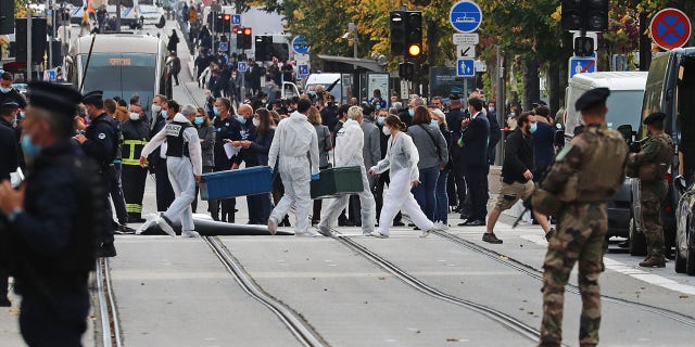 Forensics officers deploy stretchers at the site of a knife attack as French soldiers stand guard the street in Nice on Oct. 29, 2020. (Photo by VALERY HACHE/AFP via Getty Images)