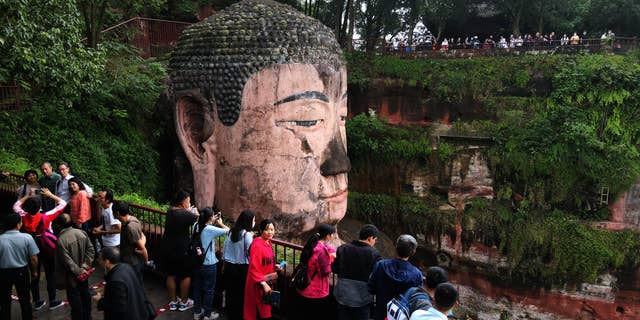 Tourists visit the Leshan Giant Buddha, a UNESCO World Heritage Site, on the first day of the eight-day National Day holiday on October 1. (Liu Zhongjun/China News Service via Getty Images)