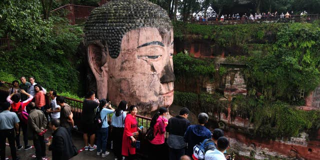 Tourists visit the Leshan Giant Buddha, a UNESCO World Heritage Site, on the first day of the eight-day National Day holiday on October 1. (Liu Zhongjun/China News Service via Getty Images)